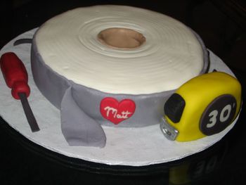 Single layer 8" cake. Screwdriver and bent nails are fondant. Tape measure is rice krispies covered in fondant.