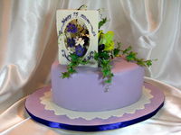 Ordered by a daughter for her mother's 75th birthday. Her request was that it include orchids and the lilies, as those were in her mom's wedding bouquet. Oh, and purple is her favorite color. The cake is cakepro's (thanks, cakepro!) lemon cake recipe (oh, so good!), two layers, torted and filled with lemon curd and fresh raspberry filling. Coated with white choc ganache, covered with white choc/cheesecake MFF. Thanks to Marie Herbstritt for the inspiration for the gum paste card.