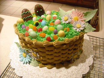 I made this for my boyfriend's family (Easter 2011). Egg-shaped pans from Wilton Course 2 class (2 layer), basket weave, grass tip, gumpaste flowers, store-bought jelly beans and peanut butter eggs. I had a handle made for the cake but it broke when I went to put it on!