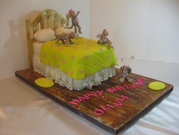 10 little monkeys jumping on the bed. 1  fell off and bumped her head. Mama called the doctor and the doctor said, "No more monkeys jumping on the bed!" Sung in a sing-song voice, this children's ditty was the theme for her 3rd birthday party. Cake is white chocolate sour cream with strawberry BC filling--covered with white choc ganache and quilted MFF overlay. Head board is pastiallge, eyelet dust ruffle is pearl clay-- (thanks Jennifer Dontz!) while the monkeys are gumpaste. The wild colors matched the party's color scheme.