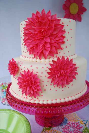 This cake was for a themed party I hosted for a friend visiting from Europe. Cake is 9" and 6" with hot pink gumpaste dahlias in different sizes; it's lemon cake with strawberry buttercream covered in fondant. I was inspired by a cake picture that was in a thread in the forums here. The picture wasn't credited so I don't know who the cake designer is. I had already made the large dahlia, just didn't know what I wanted to do with it until I saw that cake. TFL! **UPDATE** Picture was from The Knot; baker no longer in business. Thanks, vpjane, for that info!**