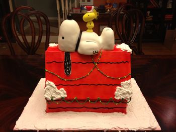 The doghouse is made out of vanilla butter cake with eggnog-flavored buttercream, covered in fondant.  Snoopy is RKT covered in fondant and Woodstock is gumpaste.  All credit for the design goes to jenbakescakes.  I'm still in the early stages of this hobby, and thus sincerely flattering others by imitation.  ;)