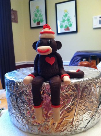 I made this gumpaste sock monkey following a youtube video I watched fhttp://www.youtube.com/watch?v=03jpbL2Ljfs  difference is I pressed in texture with a new sponge, I used an extruder, made buttons for the eyes and added a heart.