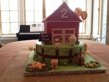 Bottom tier is yellow cake with raspberry filling and SMBC, top tier (barn) is chocolate with SMBC.  All animals handmade from fondant with tylose.  Barn is a bit wonky, but I certainly learned how NOT to put together a barn cake, which is to stay up until 4:32 a.m. holding a roof in place to dry for 32 minutes.  :)