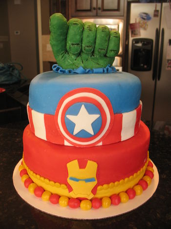 The Avengers Cake Hulk fist made from rice krispie treats covered in modeling chocolate, details painted in food coloring. Iron Man and Captain America details in fondant. www.thecrumbcoat.wordpress.com