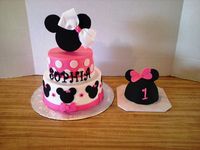 Minnie Mouse Cake: White cake with 6 & 8 inch tiers with Vanilla icing. Decorations are fondant. Topper handcut from foamboard with a real hair bow for the birthday girl made to match the cake.  Mouse Ears Smash Cake: Cake baked in 4 inch stainless steel salad bowl. White cake with Vanilla icing covered with fondant.