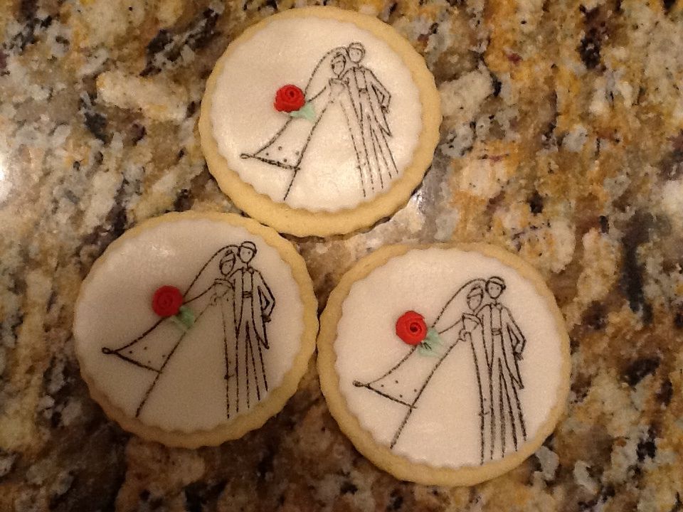 Orange flavored soft sugar cookies with orange flavored rolled buttercream, with piped royal icing rosettes.