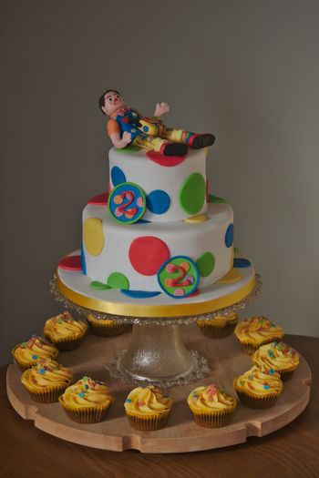 A two-tier cake with a Mr Tumble theme for twins' second birthday.