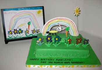 For her 6th birthday, Madeleine wanted a rabbit with a carrot in a flower garden. I asked her to paint me a picture of what she had in mind so I could replicate it in cake. Every picture she draws  contains a rainbow, so using flowed sugar for the figures, and pastillage for the rainbow & sun, here is what I came up with. It took more effort to make the wobbly rainbow and crossed lines pencil effect in the rabbit than I thought it would. The cake is strawberry with dark chocolate ganache filling, covered with white chocolate cheesecake MFF.