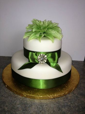 * Ivory colored fondant, Spanish cake (ponque) no filling.  Very simple for a very small intimate wedding.  Satin ribbon, golden brooche, and silk flower on top.  That was it. :)
