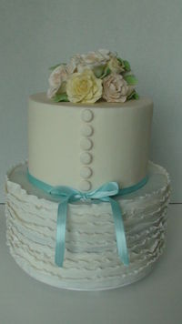 Bridal shower cake that mimics a wedding dress and bouquet. Gumpaste roses and fondant ruffles.