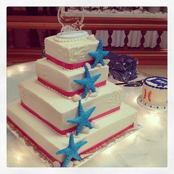 4 tier buttercream wedding cake with handmade starfish and seashells