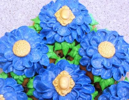 Square cupcakes, AMB buttercream, fondant gold centers.  I like the look of the Swiss Meringue Buttercream flowers the best.