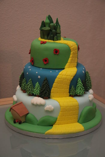 Wizard of Oz themed wedding cake including Munchkin Land, the Dark Forest, the poppy fields and the Emerald City and complete with Witch crushed by a house!
