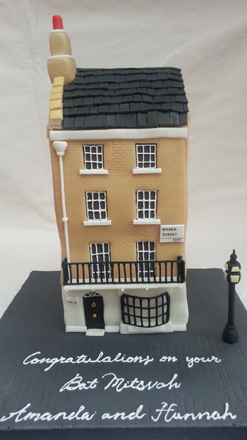 A house cake made of chocolate cake and Smbc. The cake bulged at the sides which is why the walls are wonky.  Bay window and balcony made of royal icing, everything else is fondant and gumpaste. The roof is RKT inside.
