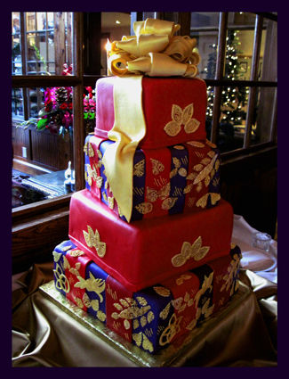 This was my challenge cake in 2013.  Gold sugar lace pieces - handcut and airbrushed gold.  Extra large gold sugar bow, purple, burgundy and red stripes.  The bride handed me a piece of wrapping paper and asked that I make the cake look exactly like it.  Had such a headache ...... but I smiled for a week in the afterglow.  :-)