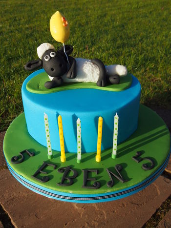 Simple decoration, Shaun lying down holding a balloon. Three layers of rich chocolate cake, white and dark chocolate ganache. Sugarpaste - Regal Ice ready to roll icing.
