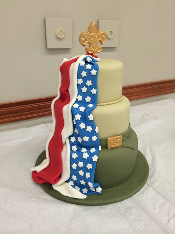 S'mores cake for my son's bridge ceremony (from cub scout to boy scout).  10-8-6, graham cracker cake, milk chocolate ganache filling, marshmallow-flavored buttercream, covered in MMF.  The red and blue fondant for the flag were Fondx, since I hate making bright colors from scratch.