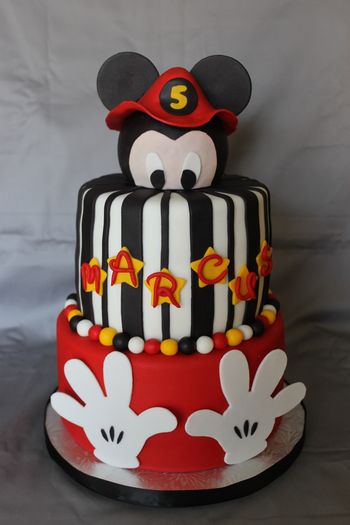I used a styrofoam ball for the head and covered it in fondant. The fireman hat was made with gum paste, and so were the hands on the bottom tier.