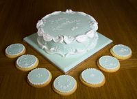 Anniversary cake with royal icing piping on fondant, with matching cookies and cupcakes