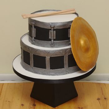 A cake for a drummer.  Gumpaste cymbal and drumsticks.  Both tiers chocolate cake with chocolate buttercream filling.