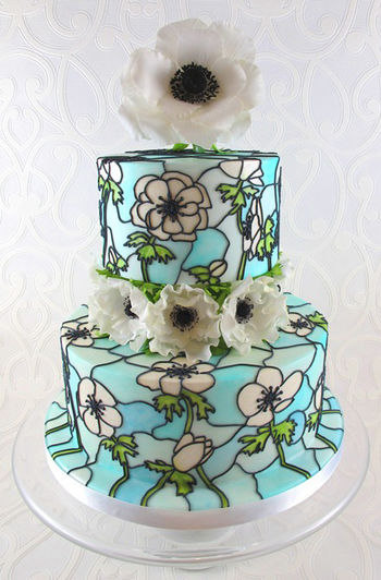 Anemone themed 'stained glass' wedding cake. This is a display cake for this springs wedding fayres. The sugar flower on top is wired with seed head stamens and the ones on the middle of the cake are totally edible. The flowers on the cake where drawn on free-hand using pictures of real flowers for reference and painted on using edible dusts and gels mixed with confectioners glaze.